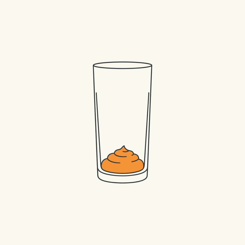 Spoon into Glass: a tall clear glass with a mound of orange puree at the bottom